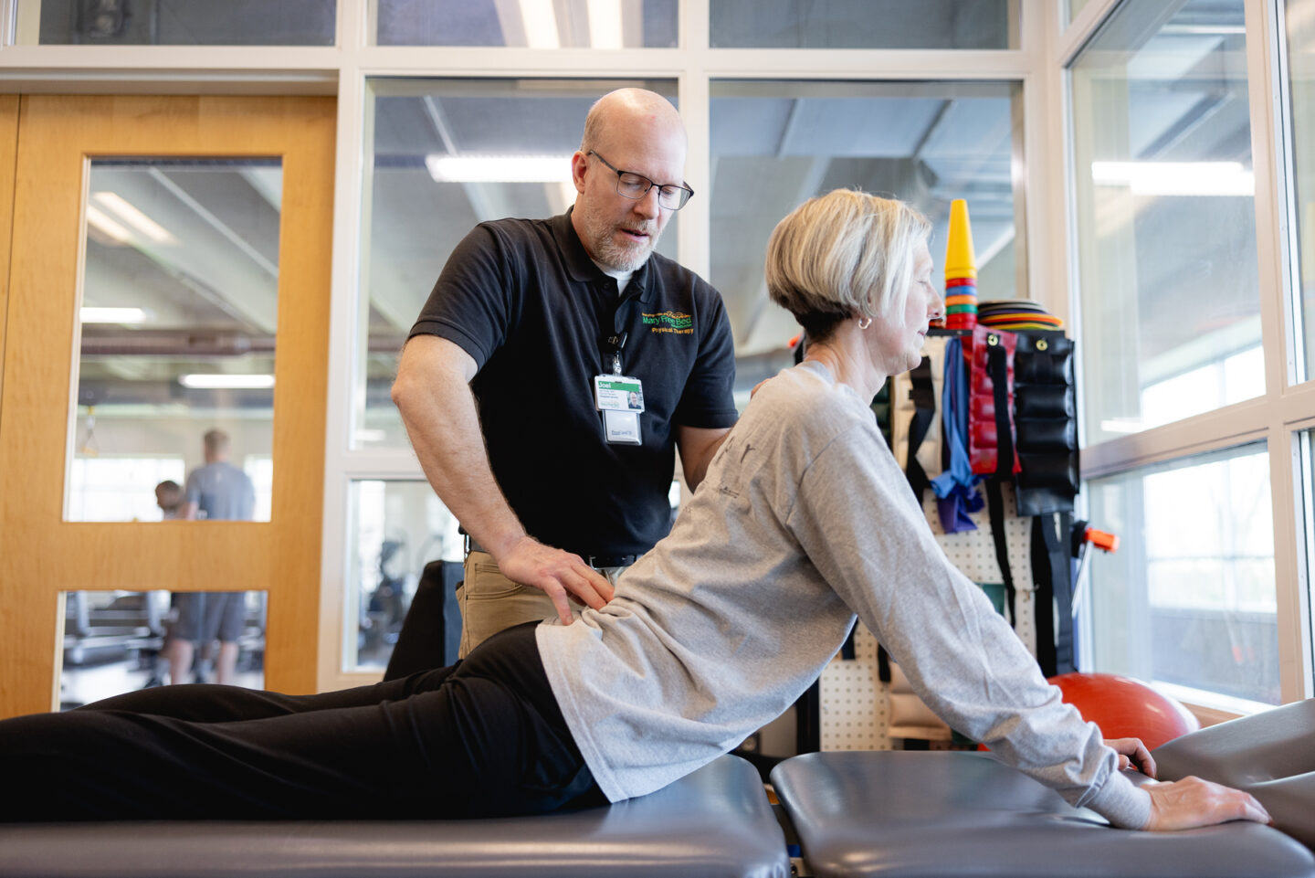 Joel Vander Wall, physical therapist, guiding patient through back pain relief exercise at Mary Free Bed Spine Center