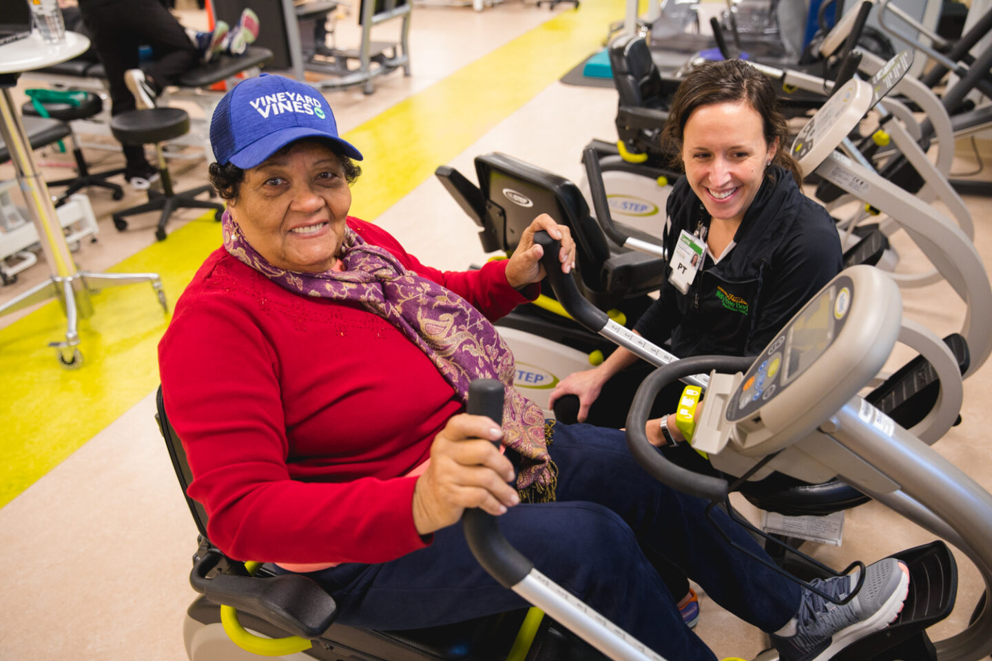 Older adult woman using a recumbent bike during an appointment with a physical therapist at Mary Free Bed.