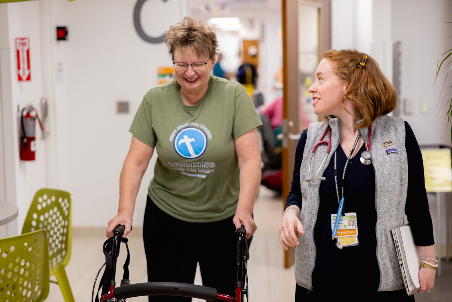 Patient walking with a walker and receiving guidance on fracture prevention.