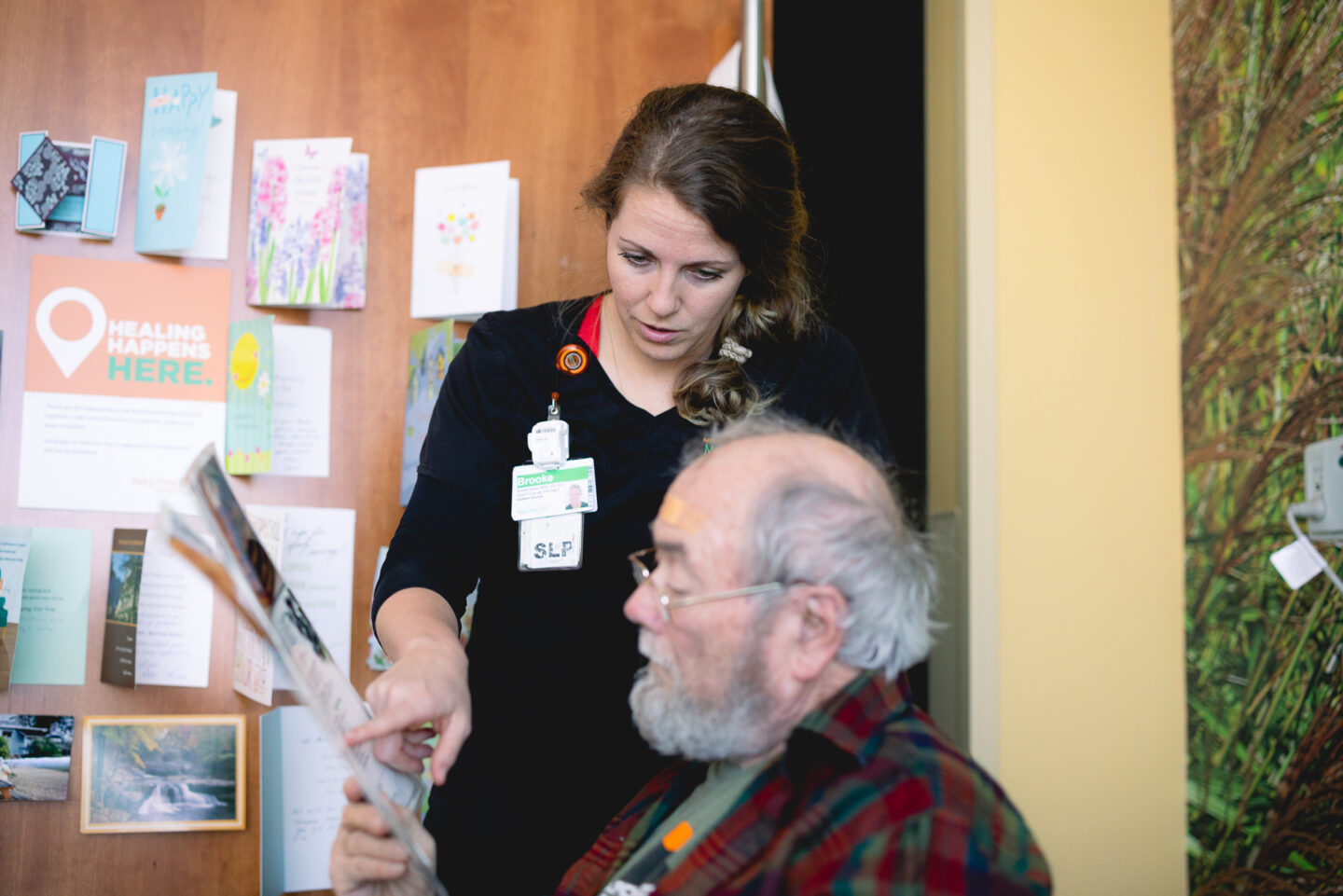 Speech-language pathologist working with a senior man on speech therapy tasks.