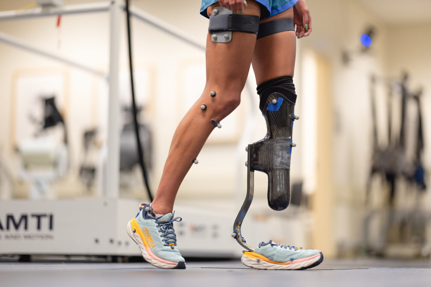 Close-up of prosthetic leg with motion capture markers for biomechanics study.
