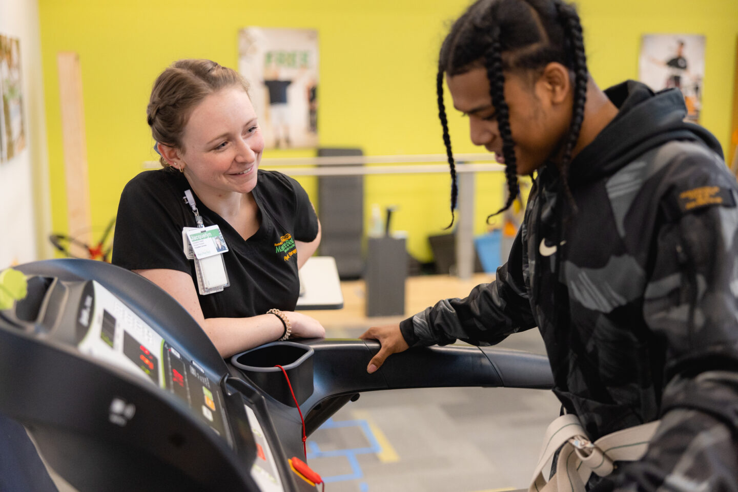 Physical therapist engaging with a patient on treadmill during therapy to improve mobility and strength.